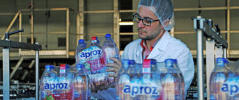 Mitarbeiter überprüft die Verpackung von Wasserflaschen Mitarbeiter überprüft die Verpackung von Wasserflaschen